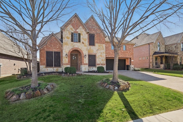 tudor-style house featuring driveway, stone siding, a front lawn, and brick siding