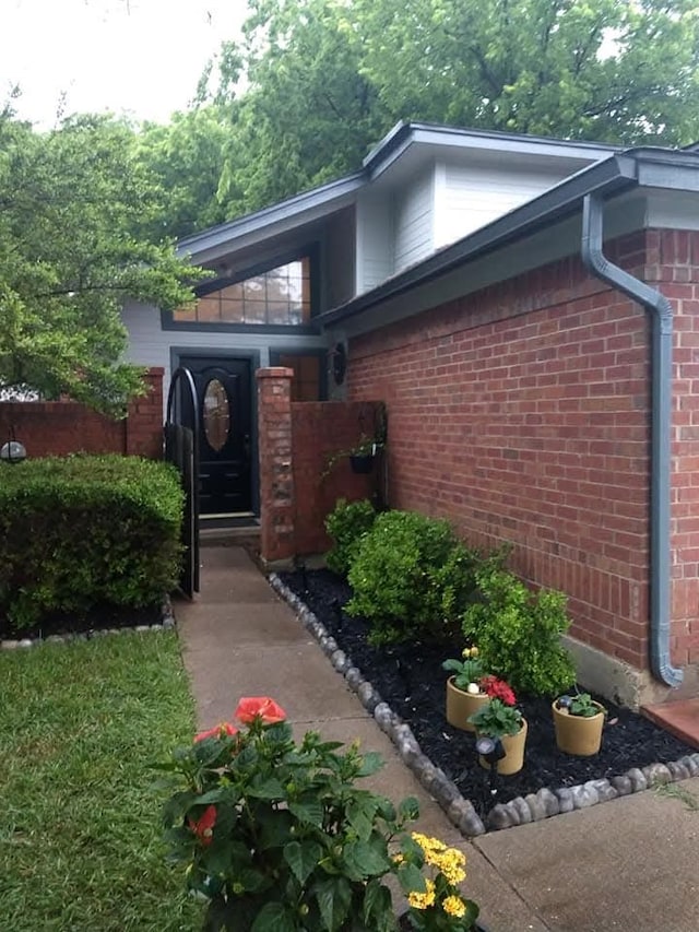 view of exterior entry featuring brick siding