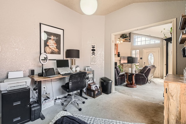 office area with vaulted ceiling and a fireplace