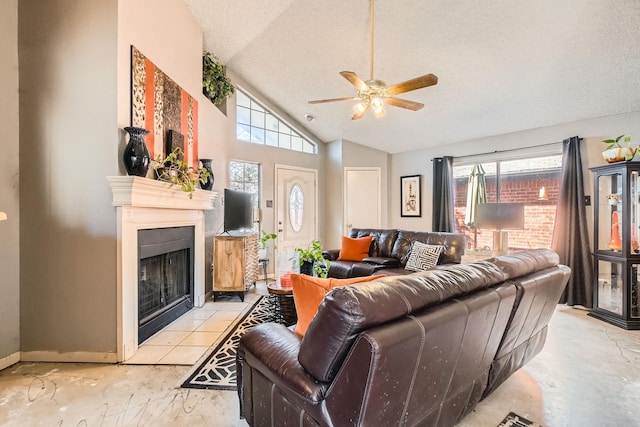 living room with a textured ceiling, plenty of natural light, a fireplace with flush hearth, and a ceiling fan