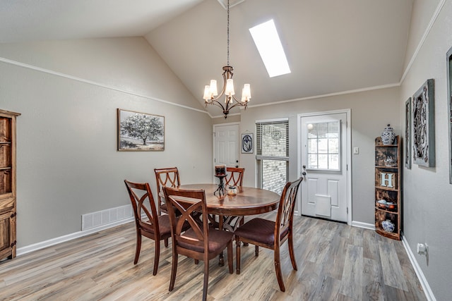 dining area featuring a chandelier, visible vents, baseboards, light wood finished floors, and lofted ceiling with skylight