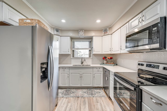 kitchen featuring stainless steel appliances, a sink, and white cabinets