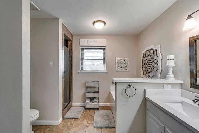 bathroom featuring a shower with door, toilet, vanity, a textured ceiling, and baseboards