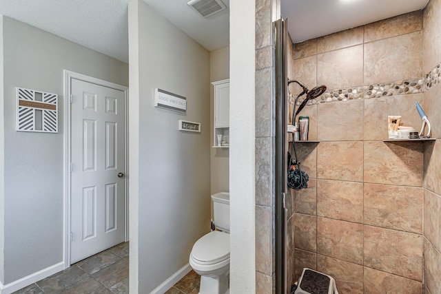 full bathroom featuring a stall shower, baseboards, visible vents, and toilet