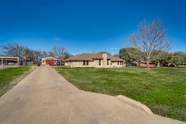 view of front of home featuring a detached garage, a front lawn, and concrete driveway