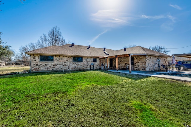 view of front of home featuring brick siding, a patio area, fence, and a front yard