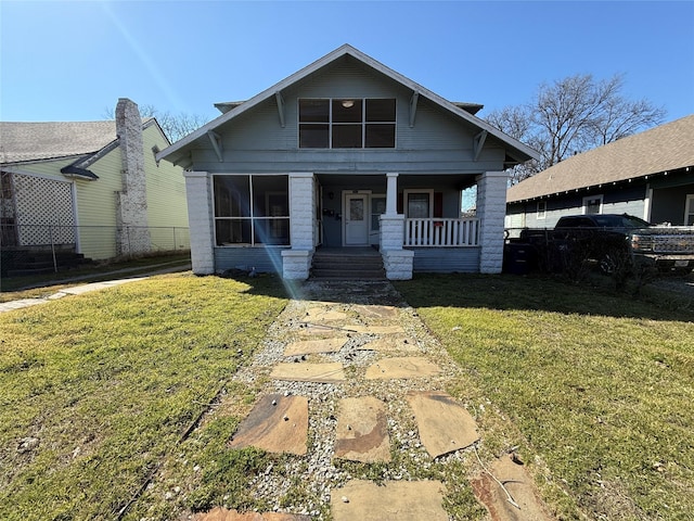 bungalow with a porch, a front yard, and fence