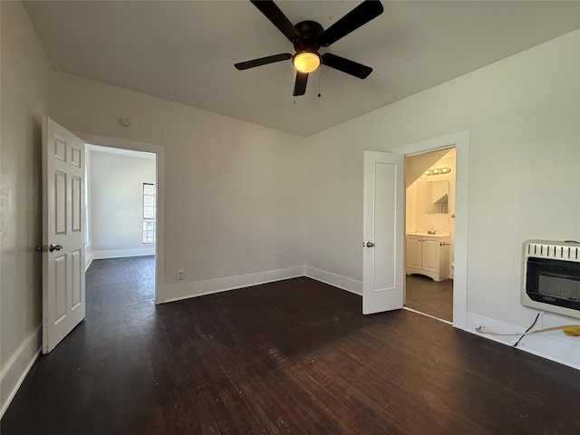 unfurnished bedroom with heating unit, a ceiling fan, baseboards, and dark wood-type flooring