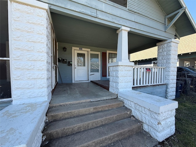 view of exterior entry featuring covered porch