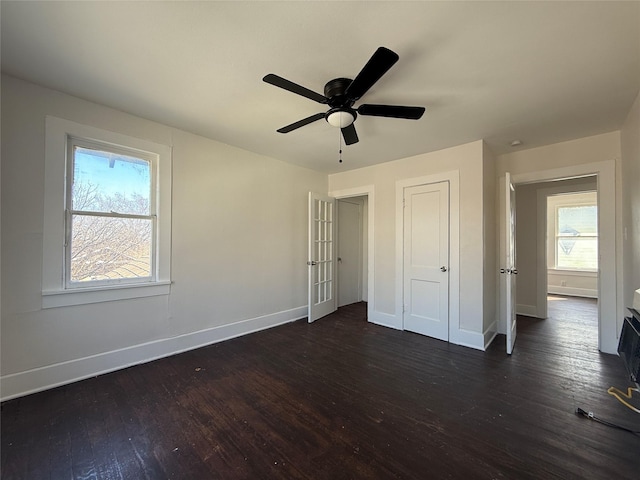 unfurnished bedroom featuring a ceiling fan, dark wood finished floors, and baseboards