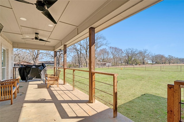 view of patio featuring a rural view, a fenced backyard, and a ceiling fan