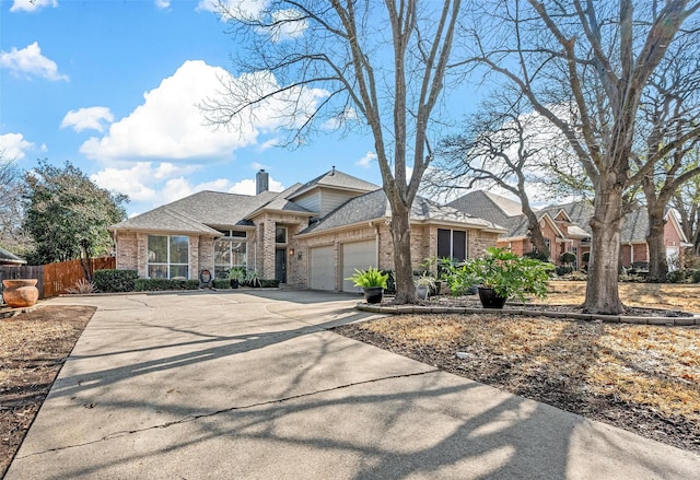 view of front of property featuring a garage, brick siding, fence, and a chimney