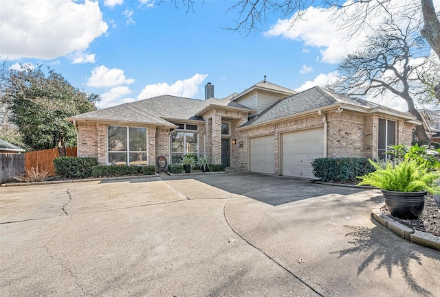 view of front of home with a garage, brick siding, fence, concrete driveway, and a chimney