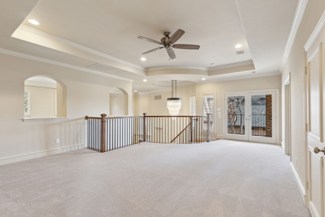 empty room featuring crown molding, a tray ceiling, recessed lighting, and light colored carpet