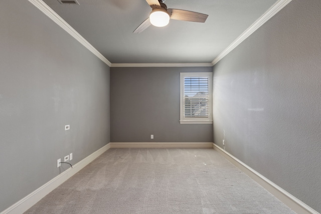 empty room with baseboards, ornamental molding, a ceiling fan, and light colored carpet