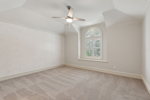 empty room featuring vaulted ceiling, ornamental molding, and light colored carpet