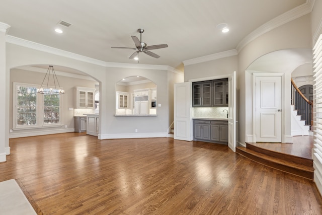 unfurnished living room featuring dark wood-style floors, stairway, visible vents, and baseboards