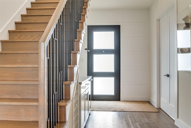 entryway featuring dark wood-style floors and stairs