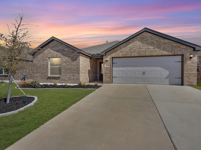 ranch-style home featuring brick siding, driveway, an attached garage, and a lawn