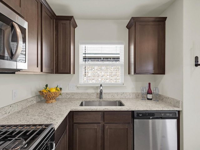 kitchen featuring dark brown cabinets, stainless steel appliances, and a sink