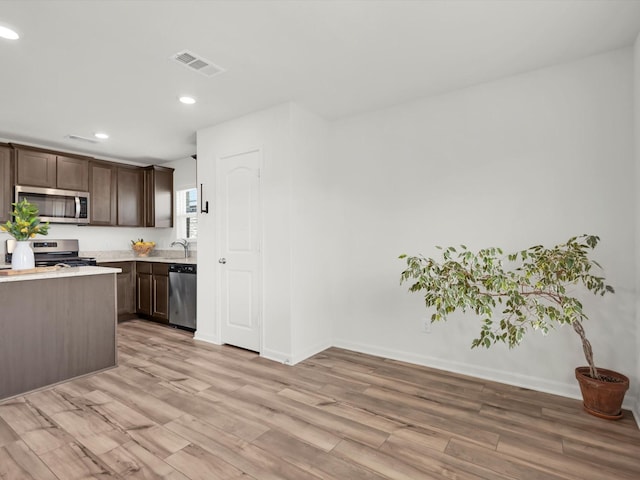 kitchen with dark brown cabinetry, visible vents, light countertops, appliances with stainless steel finishes, and hanging light fixtures