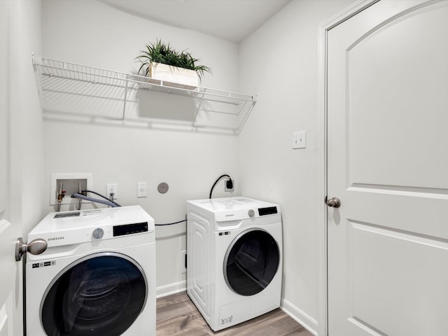 laundry area featuring light wood-type flooring, laundry area, baseboards, and separate washer and dryer