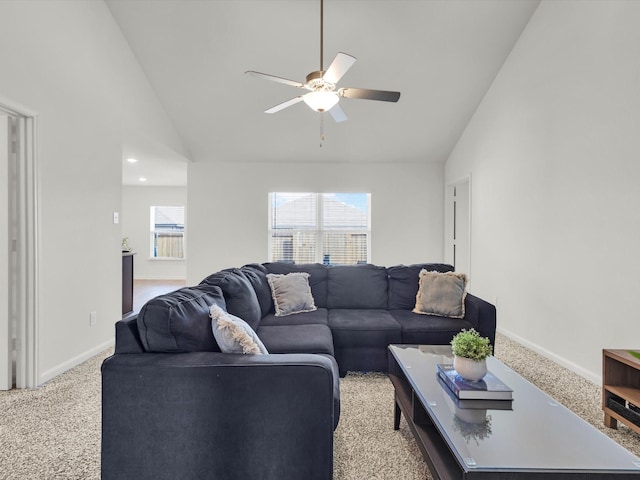 living room with light carpet, ceiling fan, high vaulted ceiling, and baseboards