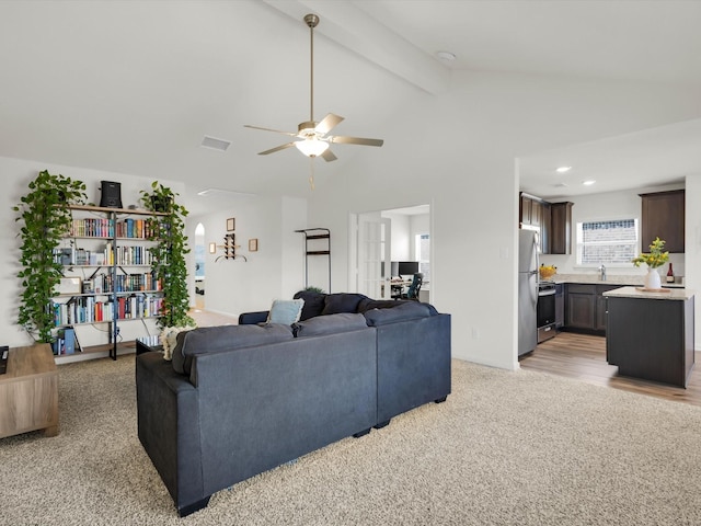 living room featuring light carpet, beamed ceiling, visible vents, and ceiling fan