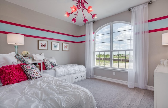 carpeted bedroom with baseboards and a chandelier