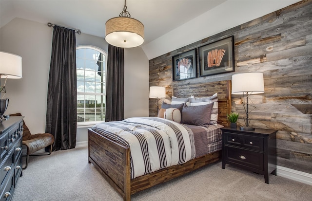 bedroom featuring light carpet, wooden walls, and lofted ceiling