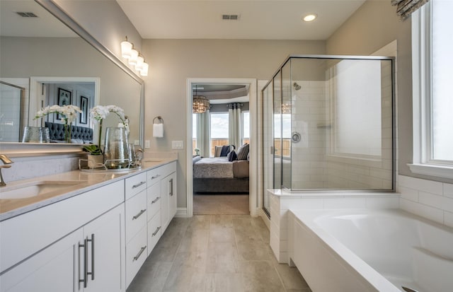 ensuite bathroom with a stall shower, visible vents, a sink, and ensuite bath