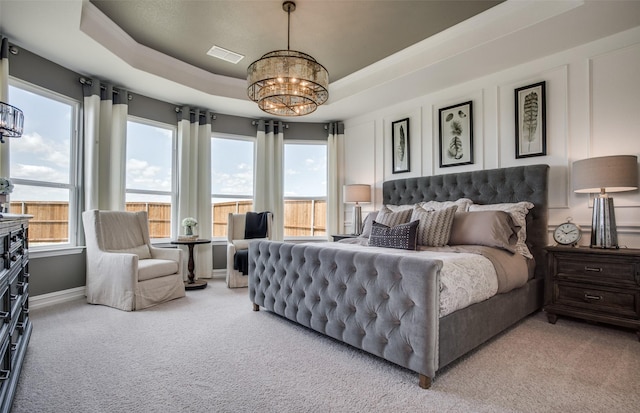 bedroom featuring a chandelier, light carpet, visible vents, baseboards, and a raised ceiling