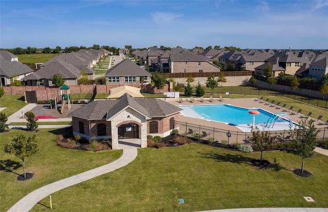 pool featuring fence, a lawn, playground community, and a residential view