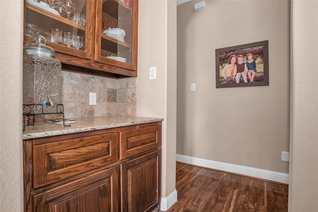 bar with dark wood finished floors, tasteful backsplash, and baseboards