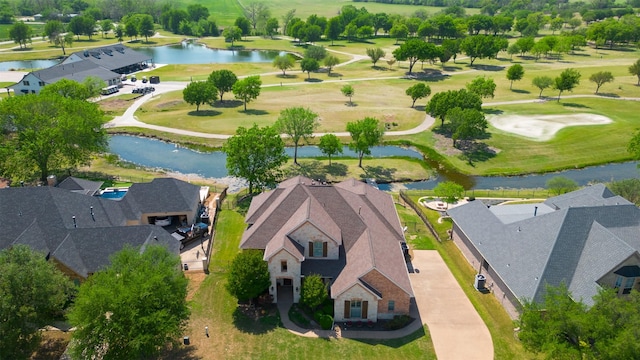 drone / aerial view featuring a residential view, golf course view, and a water view