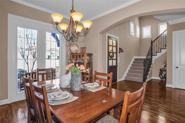 dining space featuring arched walkways, wood finished floors, a chandelier, and baseboards