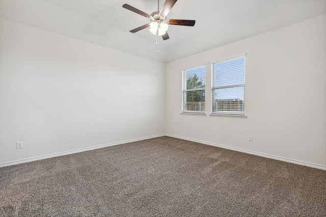 carpeted spare room with ceiling fan and baseboards