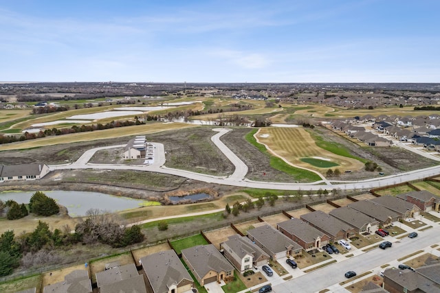 drone / aerial view featuring a water view, view of golf course, and a residential view