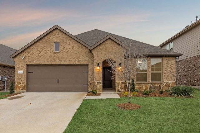 view of front of home featuring concrete driveway, a front lawn, roof with shingles, and an attached garage