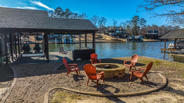 view of patio with an outdoor fire pit, a boat dock, and a water view