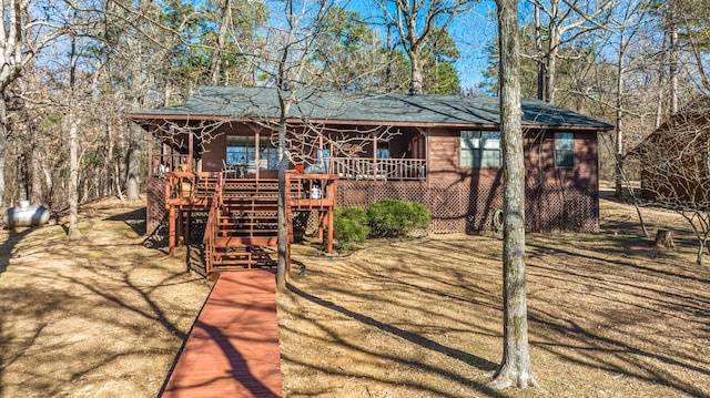 view of front facade featuring a porch, stairway, and a shingled roof