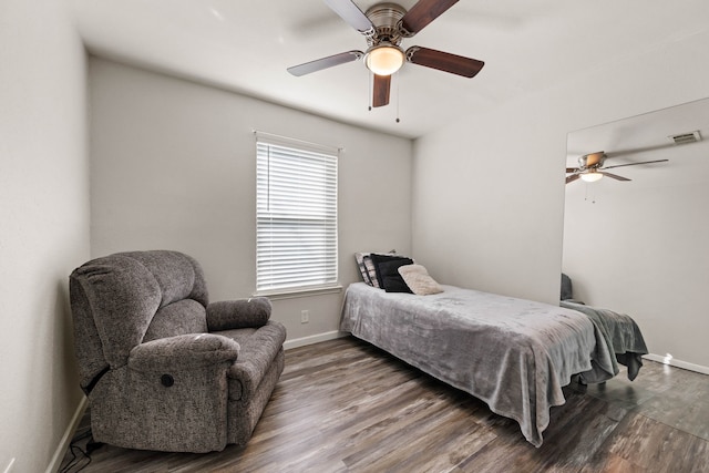 bedroom featuring ceiling fan, visible vents, baseboards, and wood finished floors