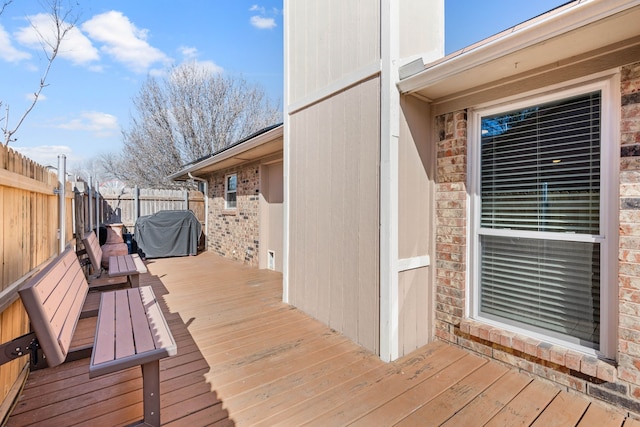 wooden terrace with area for grilling and fence