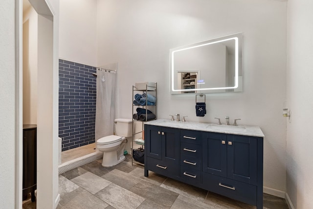 bathroom featuring a sink, toilet, double vanity, and a tile shower