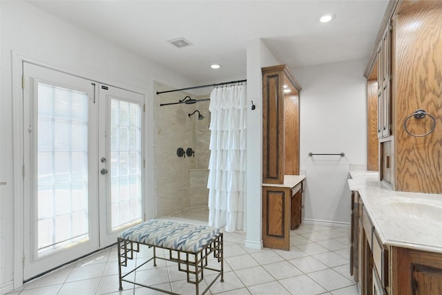 full bath with plenty of natural light, visible vents, a tile shower, and tile patterned floors