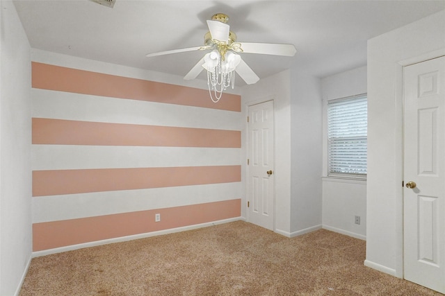 spare room with light carpet, baseboards, and a ceiling fan