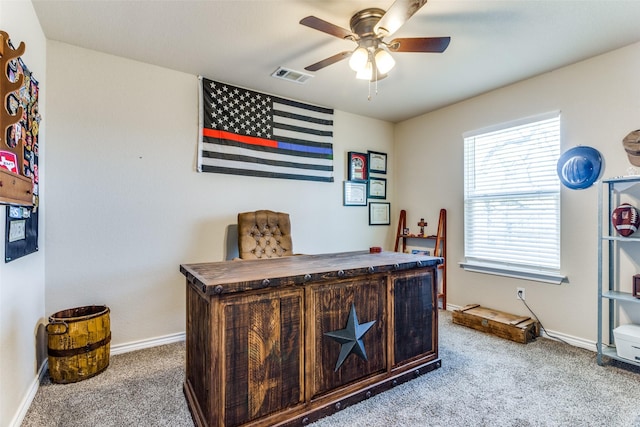 office space with carpet, visible vents, ceiling fan, and baseboards