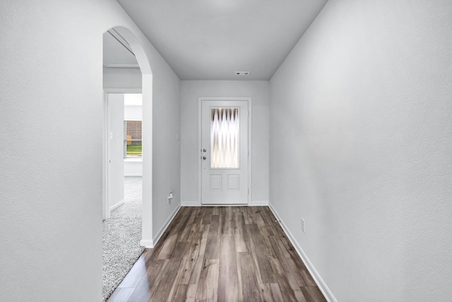 entryway with baseboards, visible vents, arched walkways, and wood finished floors