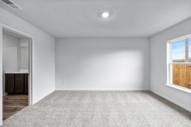 spare room featuring baseboards, visible vents, and carpet flooring