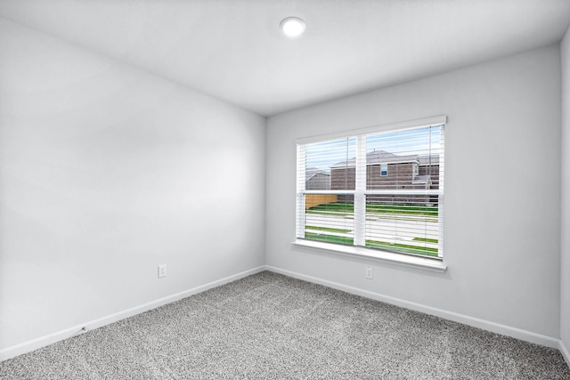 unfurnished room featuring carpet flooring and baseboards